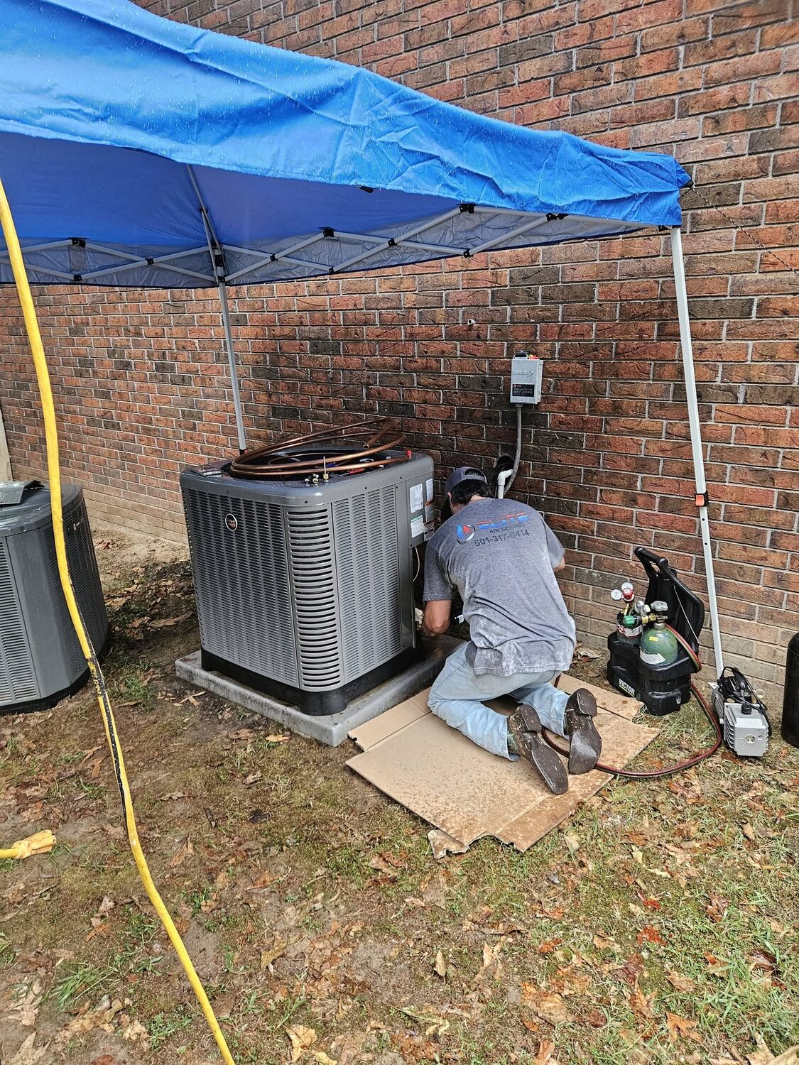 Elite Air technician servicing an outdoor AC unit
